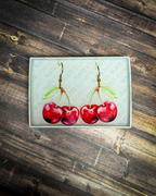Red cherry acrylic earrings with gold hook hardware displayed inside a premium Slate & Ember jewelry gift box.